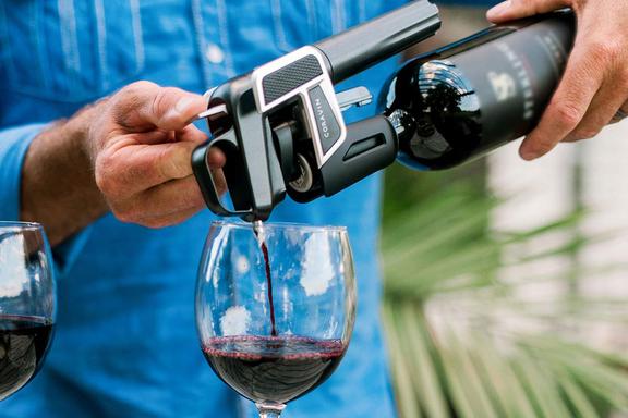 A man pouring wine from Coravin Model Two Premium Wine Preservation System in a wine glass