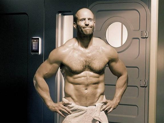 Shirtless Jason Statham with only a towel wrapped around his hips