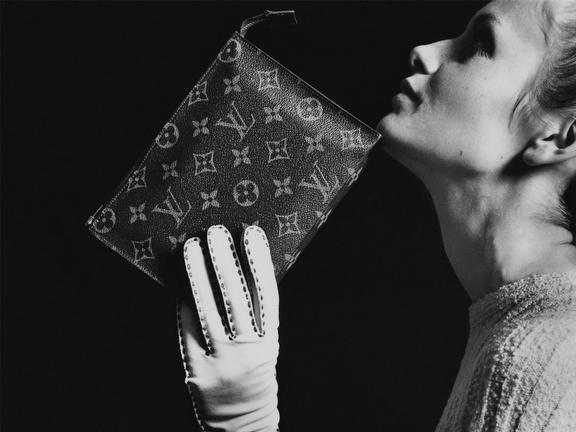 Woman wearing a glove holding a Louis Vuitton purse